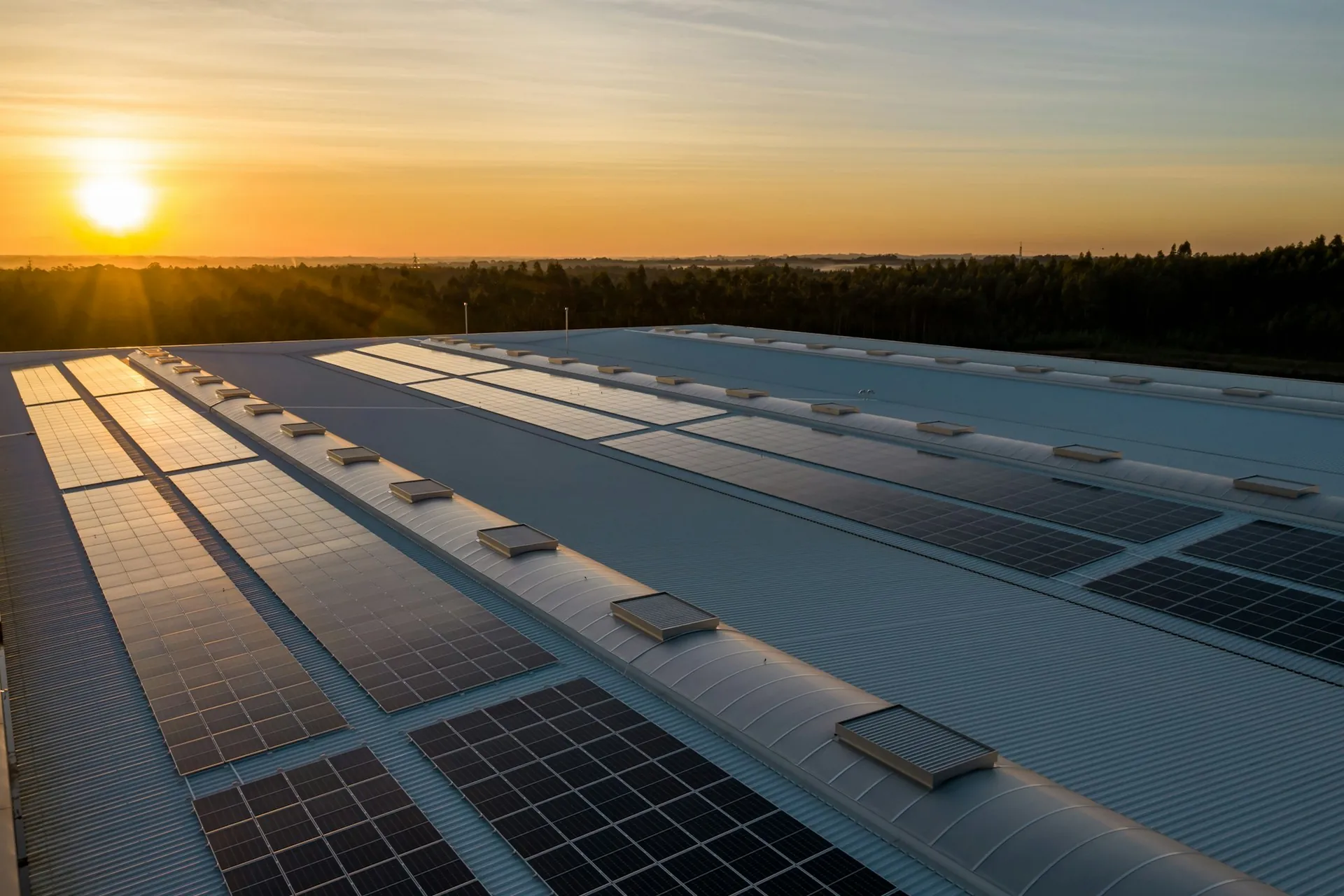 Impianto fotovoltaico sul tetto di un edificio al tramonto
